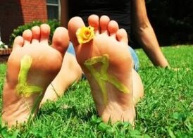Pieds sans champignon avec une fleur entre les doigts